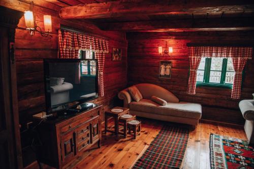 a living room with a couch and a television at Etno selo Stanišići Etno kuće in Dijelovi
