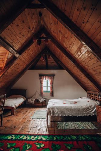 a attic room with two beds and a window at Etno selo Stanišići Etno kuće in Dijelovi