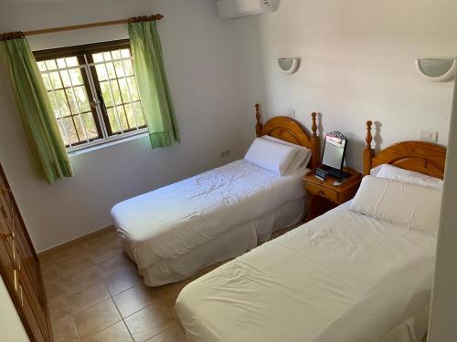 a bedroom with two beds and a laptop on a table at Las Brisas, Villa 98 in Playa Blanca