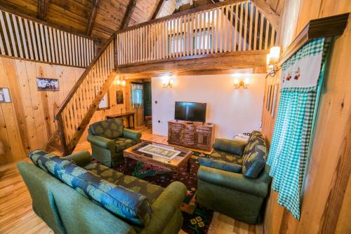 a living room with couches and a television in a cabin at Etno selo Stanišići Etno kuće in Dijelovi