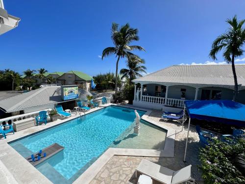 a swimming pool in front of a house at Sun Caraibes in Orient Bay