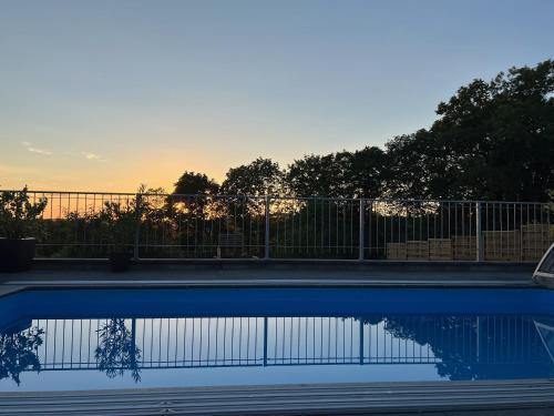 a swimming pool with the sunset in the background at Ferienhaus Eisfelder Blick in Eisfeld