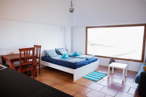 a room with a bed and a table and a window at Castillo de Villaverde in Villaverde