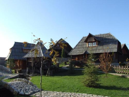 a group of wooden houses with a yard at Etno selo Stanišići Etno kuće in Dijelovi