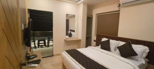 a bedroom with a bed and a window with a table at Nebo Suites in Visakhapatnam