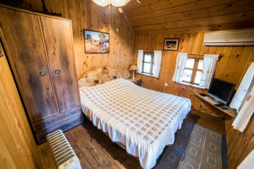 a bedroom with a bed and a television in it at Etno selo Stanišići Etno kuće in Dijelovi