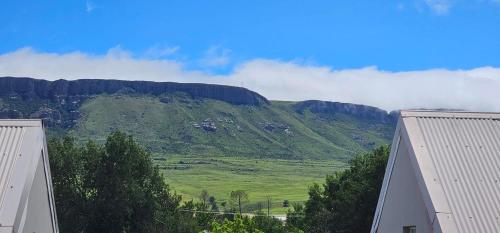 a view of a green mountain with clouds in the background at Grazia Overnight accommodation in Harrismith