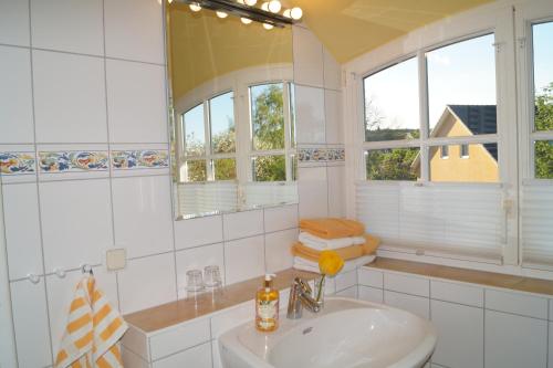 a white bathroom with a sink and a mirror at Reethaus im Biosphärenreservat in Lancken-Granitz