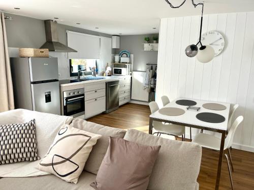 sala de estar con sofá, mesa y cocina en Joli T2 3* 40 m2 avec parking et terrasse, en Aix-les-Bains