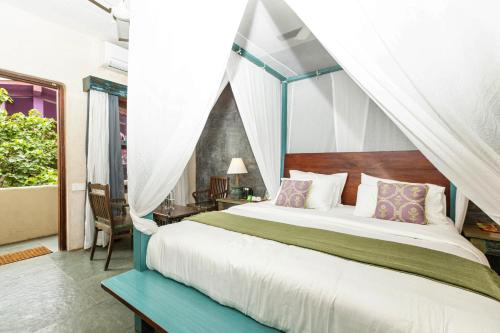 亞蘭博的住宿－GERANIUM HAVEN，一间卧室配有一张带天蓬的床