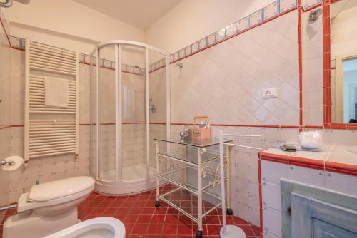 uma casa de banho com um WC, um chuveiro e um lavatório. em Bilocale vista mare al Castello em Piombino
