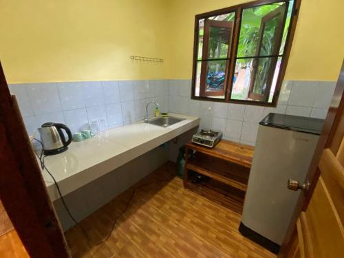 une cuisine avec une baignoire, un évier et une fenêtre dans l'établissement Bungalow in the jungle, à Salad Beach