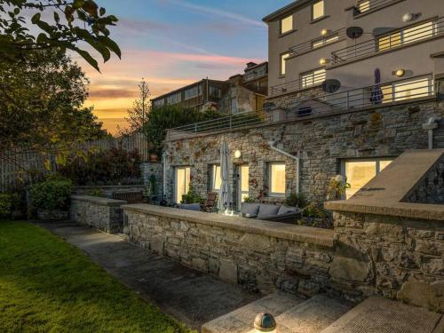 a house with a stone wall and a building at Clifden Seaview - Spectacular Apartment, Connemara in Clifden