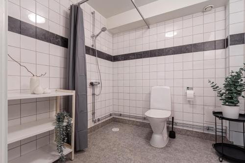 a white tiled bathroom with a toilet and a shower at Charming Apt in Sodermalm in Stockholm