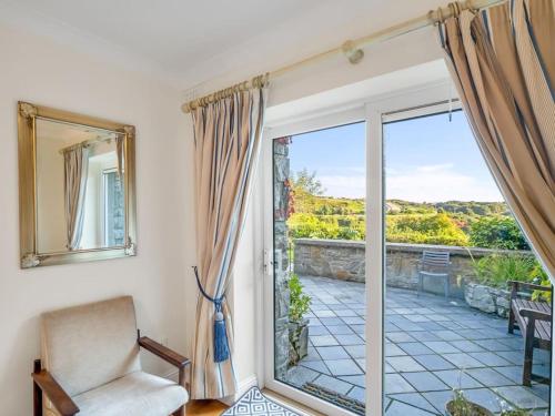 a living room with a chair and a sliding glass door at Clifden Seaview - Spectacular Apartment, Connemara in Clifden