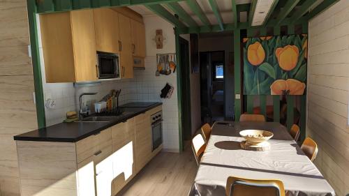 a kitchen with a table and a sink and a table and chairs at Appartement- Villard de Lans-8 pers in Villard-de-Lans