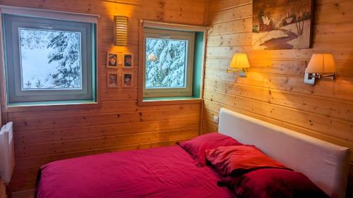 a bedroom with a red bed in a wooden wall at Appartement- Villard de Lans-8 pers in Villard-de-Lans