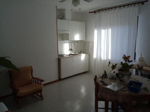 ein Wohnzimmer mit einem Tisch und einer Küche in der Unterkunft L'Erbetta fra le Cinque Terre e la Val di Vara in Riccò del Golfo di Spezia