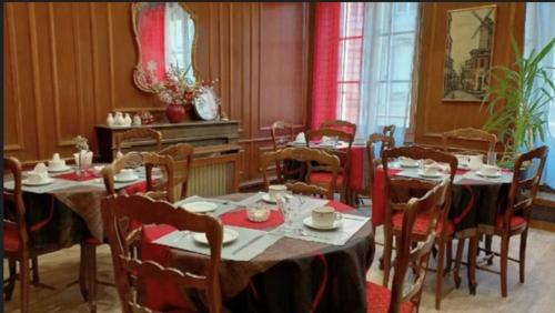 ナンシーにあるオテル ド ラカデミーのダイニングルーム(テーブル2台、椅子、テーブル、椅子付)