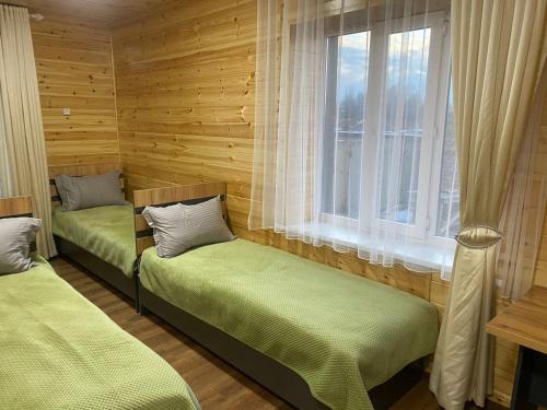 two beds in a room with a window at Syi-Ordo Hotel in Pokrovka