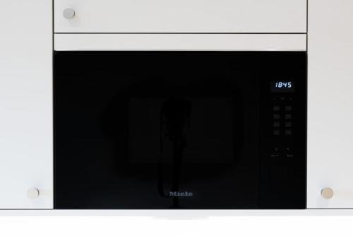 a microwave oven with its door open with a black door at Slope-Side Fun Ski-In Ski-Out Retreat for 3 in Åre