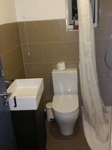 a bathroom with a white toilet and a sink at LOVELY 1 BED FLAT WITH GOOD TRANSPORT LINKS. in Morden
