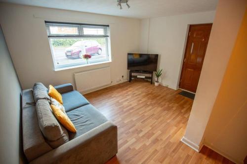 a living room with a couch and a television at Entire 1 Bedroom House in Manchester in Manchester