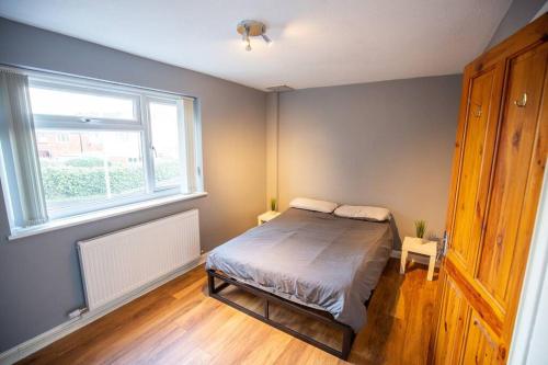 Entire 1 Bedroom House in Manchester في مانشستر: غرفة نوم بسرير ونافذة