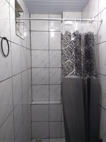 W łazience znajduje się prysznic z zasłoną prysznicową. w obiekcie Residencial Nanda w mieście Salvador