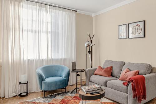 a living room with a couch and a blue chair at The Covent Courtyard Flat in London