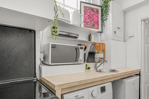 a small kitchen with a microwave and a sink at The Covent Courtyard Flat in London