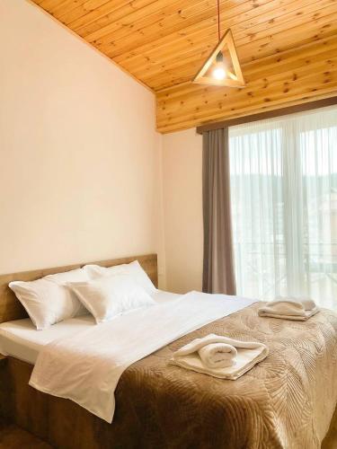 a bedroom with a large bed with a window at Memories House in Bakuriani
