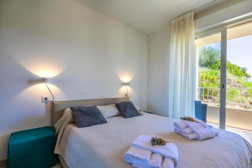 a bedroom with a large bed with towels on it at Residence A Marina in Lumio