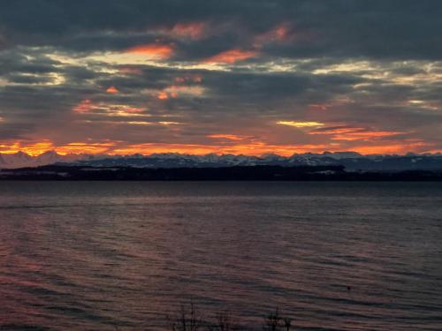 a sunset over a large body of water at La crique de l'evole in Neuchâtel
