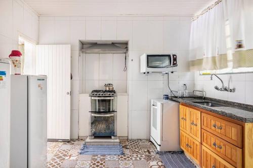 a kitchen with a refrigerator and a stove top oven at Casa Papai Noel in Campos do Jordão