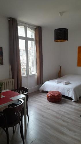 een slaapkamer met een bed, een tafel en een raam bij Chez Eric le n2 in Tours