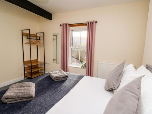 a bedroom with a large white bed and a window at Afonwy House in Rhayader