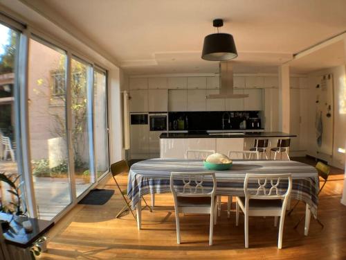 une cuisine avec une table et des chaises dans une pièce dans l'établissement Maison à 5 minutes du métro, à Issy-les-Moulineaux