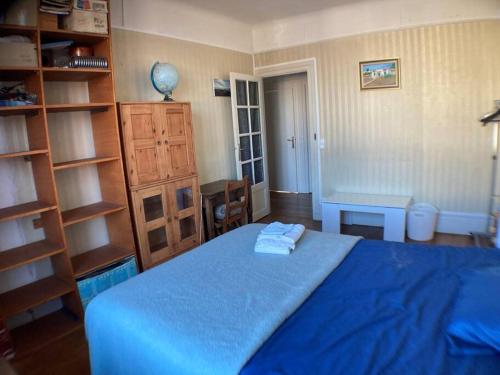 - une chambre avec un lit bleu et une étagère dans l'établissement Maison à 5 minutes du métro, à Issy-les-Moulineaux