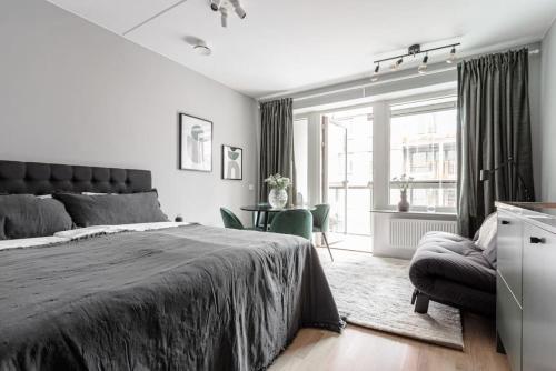ein Schlafzimmer mit einem Bett, einem Stuhl und einem Fenster in der Unterkunft Beautiful and cozy Studio in a New building in Stockholm