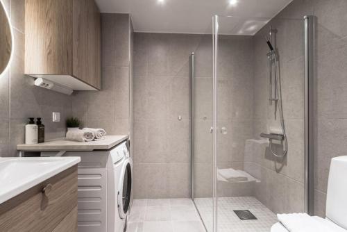 ein Bad mit einer Dusche und einer Waschmaschine in der Unterkunft Beautiful and cozy Studio in a New building in Stockholm