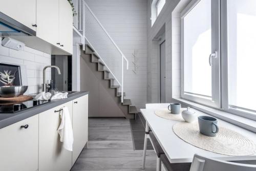 una cocina con armarios blancos y una escalera en Discover Gothenburg from equpped Studio, en Gotemburgo