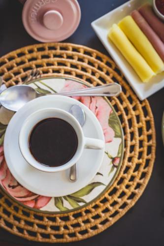 a cup of coffee on a plate on a table at Quinta da Bocaina in Amparo