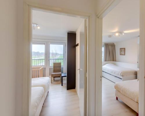a hotel room with two beds and a balcony at La Cabane Penthouse in Nieuwvliet-Bad