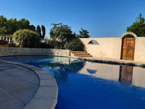 une piscine d'eau bleue et une maison dans l'établissement Maison de la Mascotte, à Châteaurenard