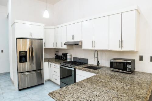 a kitchen with white cabinets and stainless steel appliances at VILLA COSTA FELIX 1 in Puerto Peñasco