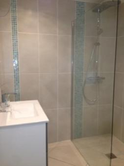 une salle de bain avec une douche en verre et un lavabo dans l'établissement Vue Mer, deux plages à proximité, à Collioure