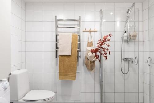 a white bathroom with a shower and a toilet at Central Gothenburg Retreat for 6 guests in Gothenburg