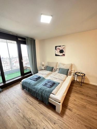 ein Schlafzimmer mit einem großen Bett und großen Fenstern in der Unterkunft Urban Zen Residence in Hannover