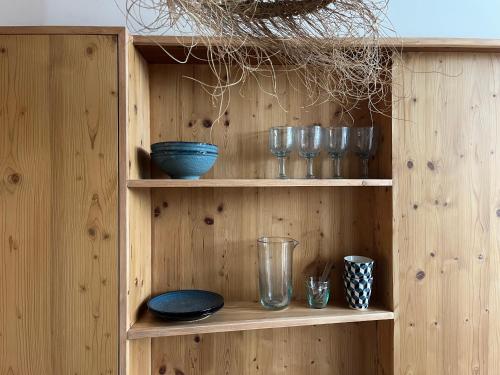 une étagère en bois avec des bols et des verres dans l'établissement un nid avec balcon, à Saint-Gervais-les-Bains